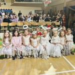 dzieci siedzą na ławeczce w strojach aniołków