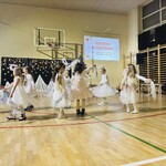 dziewczynki tańczą w strojach tańczą w strojach aniołków z szarfami