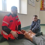 dzieci ćwiczą resuscytacje krążeniowo- oddechową na fantomach