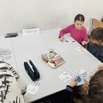 dzieci siedzą przy stole rozwiązują zagadki