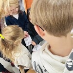 dzieci czytają napisy na kartkach 