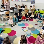 dzieci siedzą w kręgu na dywanie