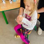 dziewczynka siedzi , trzyma naczynie laboratoryjne