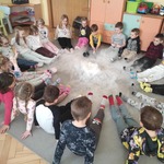 grupa dzieci siedzi na dywanie 