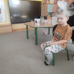 chłopiec siedzi , nad jego głową unosi się para
