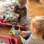 dziewczynka pomaga zdejmować chłopcu kapcie