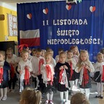 dzieci tańczą z biało- czerwonymi wstążkami.jpeg