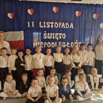 dzieci z grupy Motylki pozują z paniami na tle dekoracji.jpg