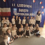 dzieci z grupy Żuczki pozują z paniami na tle dekoracji.jpg