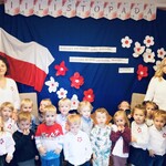 grupa pozuje na tle flagi  biało czerwonej
