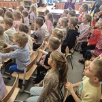 dzieci z zaintreresowaniem oglądają przedstawienie o smoku i królewnie.jpg