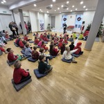 dzieci siedzą na poduszkach w sali konferencyjnej.jpg