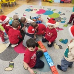 dzieci ubrane na czerwono wykonują zadania na dywanie