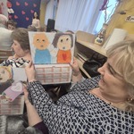 babcia trzyma podarowany przez wnuczkę prezent- laurkę z portretem i kalendarzem.jpg