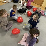 dzieci trzymają się za głowy podczas zabawy z balonami