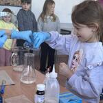 dziewczynka pomaga wykonać doświadczenie chemiczne.jpg