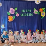dzieci w opaskach siedzą przed dekoracją.jpg