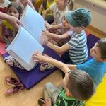 dzieci poznają książkę napisaną alfabetem Braille’a.jpg