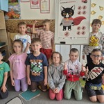 dzieci pozują przy tablicy z Kotkiem Bofkiem Superbohaterem.jpg